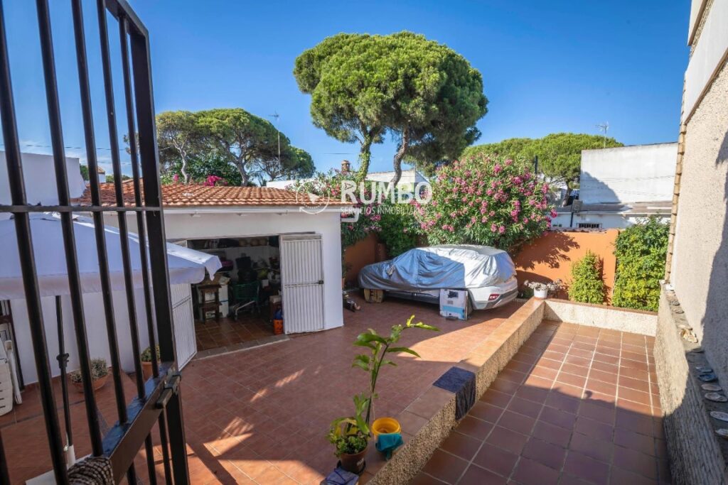Salón comedor con muebles de madera, espejo grande y pared de piedra